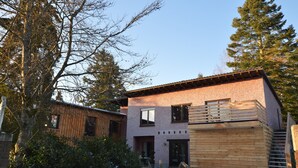 A modern two-story house with a wooden deck and a brick exterior. - Cosy Apartment in Manderscheid With Balcony (Manderscheid)