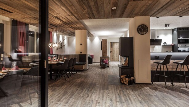 A modern interior with a dining area, kitchen, and seating space. - Chalet Montafon in Gaschurn With Sauna (Gaschurn)