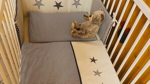 Una culla con biancheria a righe e decorazioni a stella.