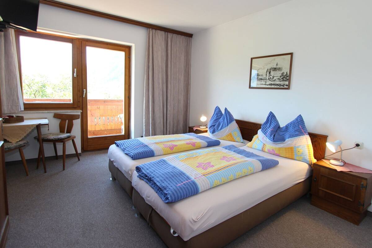 Een hotelkamer met een groot bed, een bureau en een stoel.