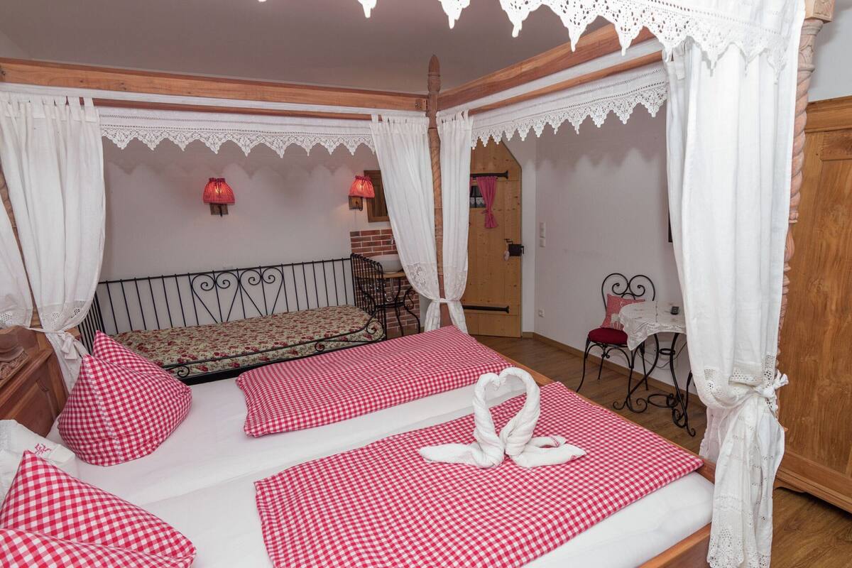 A bedroom with a four-poster bed, checkered bedding, and a canopy.