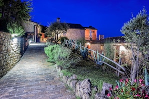 A stone pathway leading to a stone building with a wooden fence and greenery. - Gorgeous Apartment With Pool Near Sibillini Mountains (Monte San Martino)