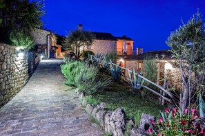 A stone pathway leading to a stone building with a wooden fence and greenery. - Gorgeous Apartment With Pool Near Sibillini Mountains (Monte San Martino)