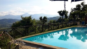 A swimming pool with a view of mountains and a wooden fence. - Gorgeous Apartment With Pool Near Sibillini Mountains (Monte San Martino)