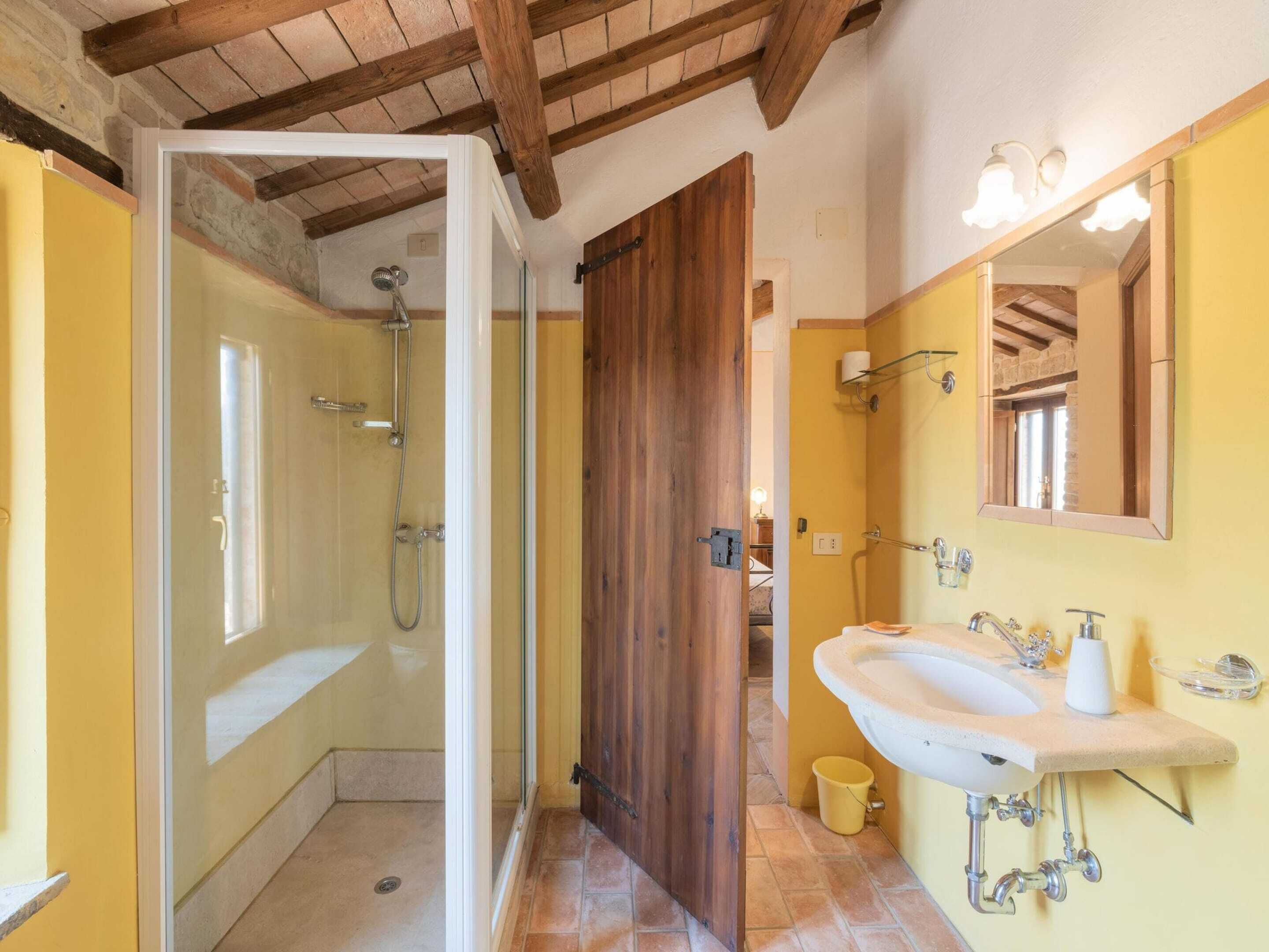 A bathroom with a shower, a sink, and a mirror.