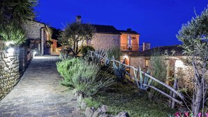 A stone pathway leading to a stone building with a tiled roof, surrounded by vegetation and a wooden fence. - Gorgeous Apartment With Pool Near Sibillini Mountains (Monte San Martino)