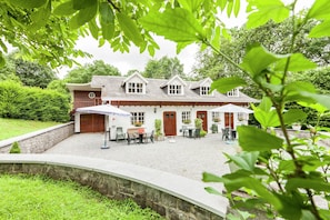 A traditional house with a stone wall, a gravel patio, and a wooden door. - House Situated on a Magnificent Estate (Durbuy)