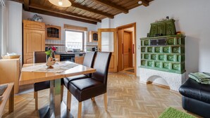 A spacious kitchen with wooden cabinets, a dining table with chairs, and a green appliance. - Beautiful Holiday Home in Viechtach With Views (Viechtach)