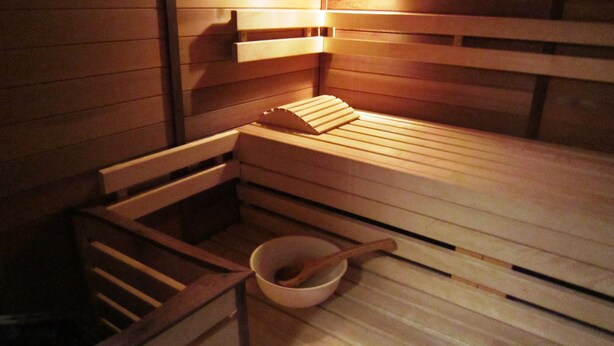 A wooden sauna with benches and a wooden bowl with a spoon. - Lovely House With Much Luxury and Comfort (Waimes)
