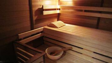 A wooden sauna with benches and a wooden bowl with a spoon.