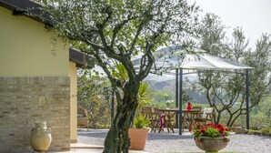 A patio with a table and chairs, a pergola, and a view of the landscape. - Inviting Holiday Home in San Costanzo With Swimming Pool (San Costanzo)