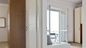 A modern interior with a wooden wardrobe, a glass door leading to a balcony, and a seating area with a view. - Amazing Holiday Home Near Pet-friendly Beach (Carrara)
