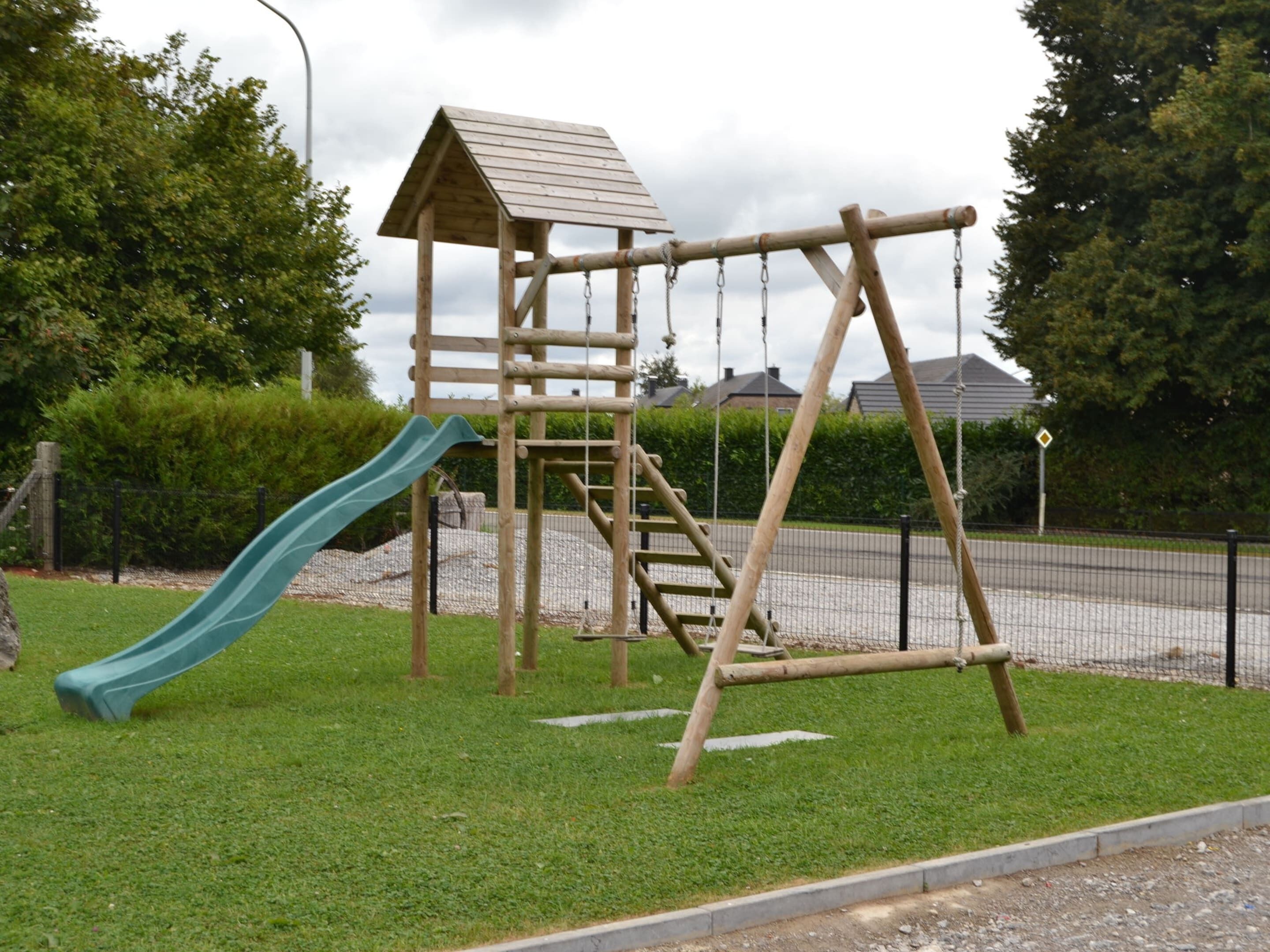 Eine Spielgeräte aus Holz mit Rutsche und Kletterelementen.