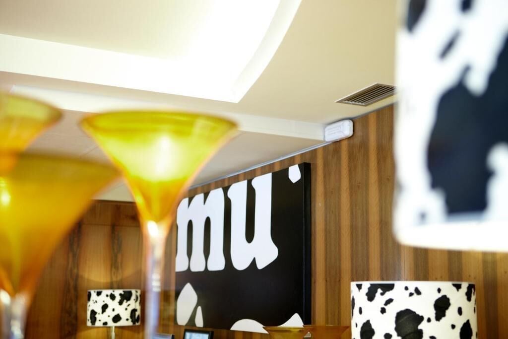 Zona de bar con pared de madera y un gran letrero que dice 'mu'.