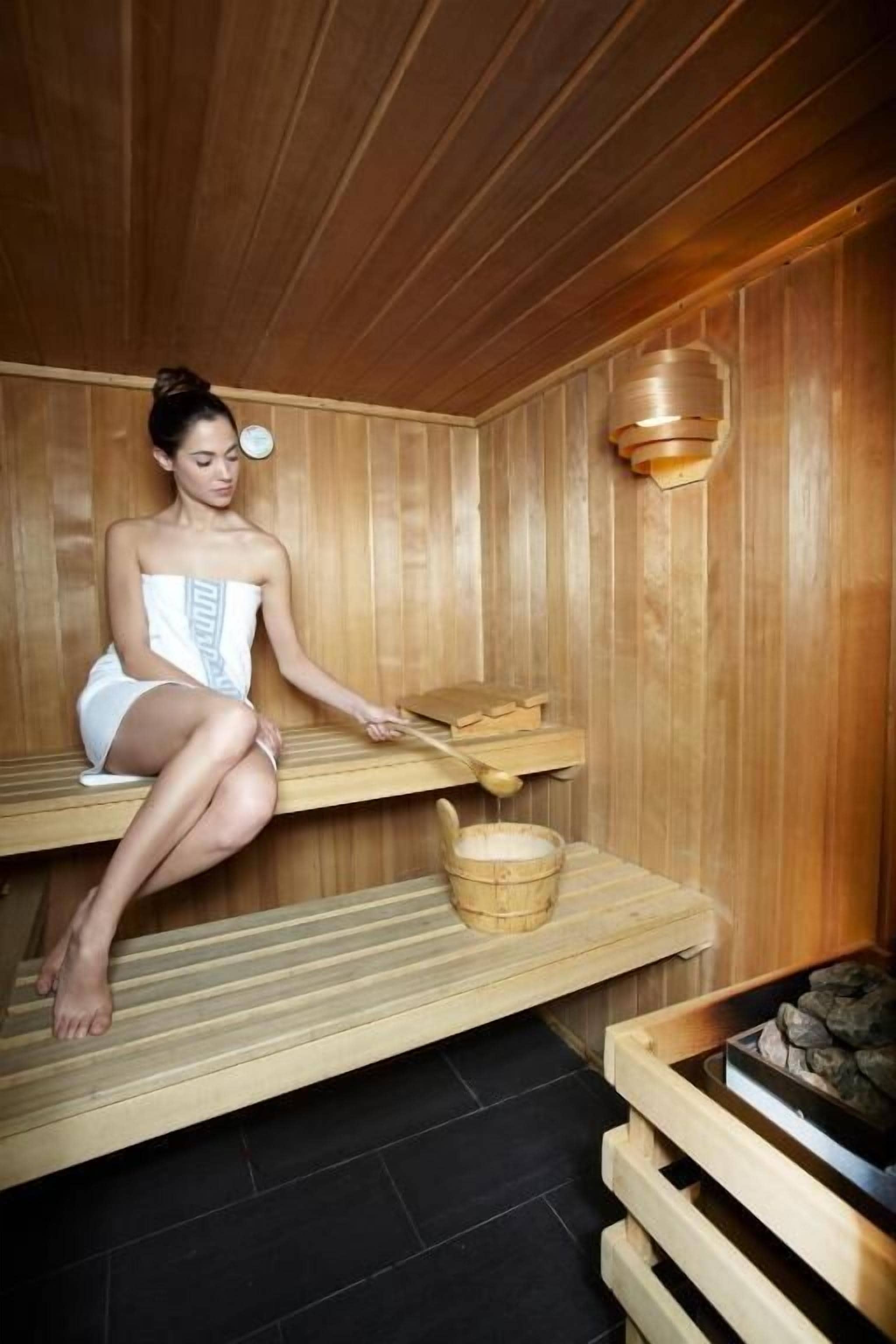 A sauna with wooden benches and a wooden wall.