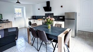 Een moderne keuken met een eethoek, een wasmachine en een koelkast.
