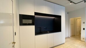 A modern kitchen with built-in appliances, a black countertop, and a sleek design. - Modern Holiday Home in Bazel With Garden (Kruibeke)