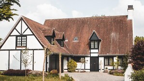 A traditional half-timbered house with a cobblestone driveway and a well-maintained garden. - Modern Holiday Home in Bazel With Garden (Kruibeke)
