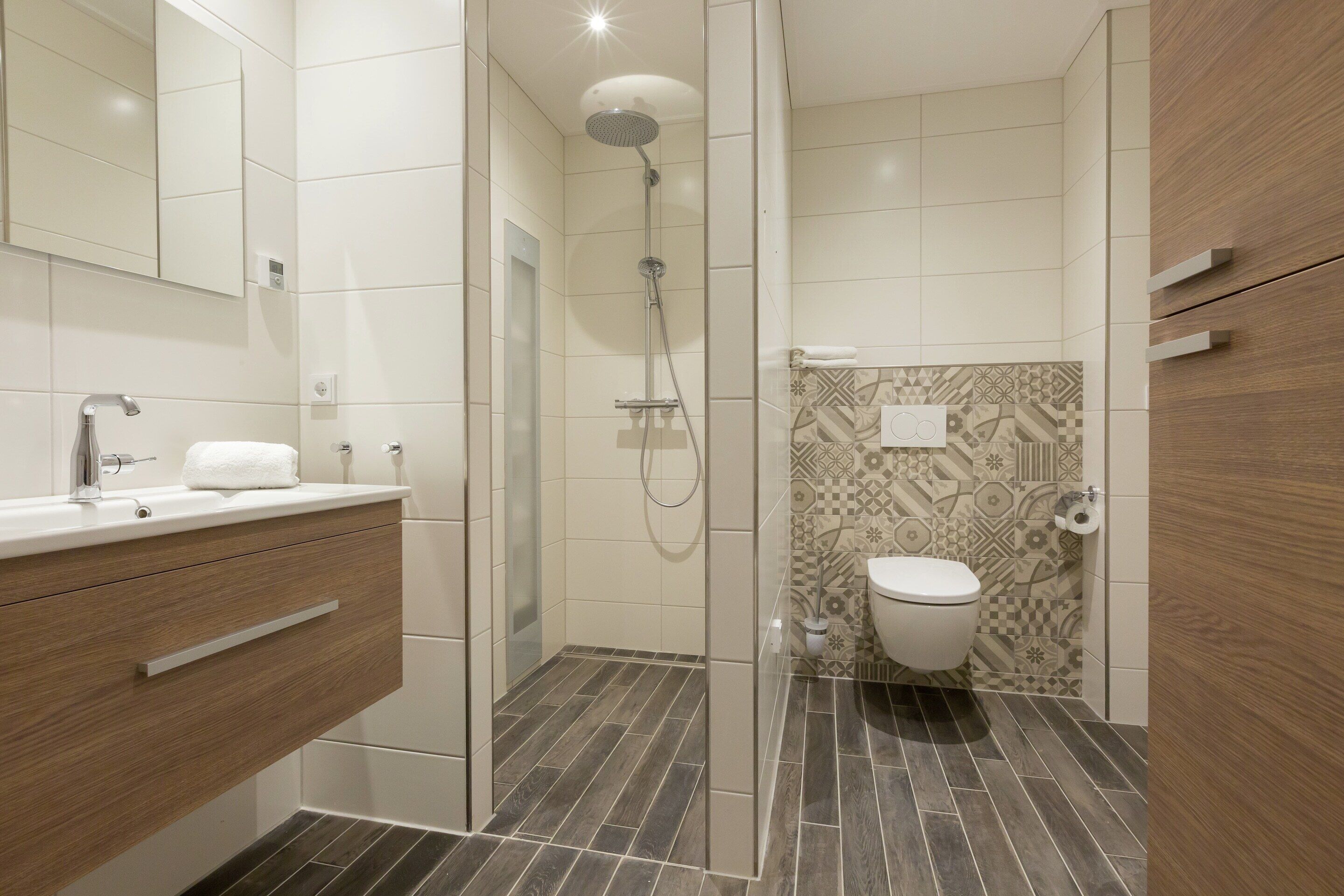 Ein modernes Badezimmer mit Dusche, Toilette und Waschtisch.