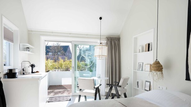 A modern hotel room with a bed, a desk, and a balcony. - Pleasaing Holiday Home in Oostkapelle Near Centre (Oostkapelle)