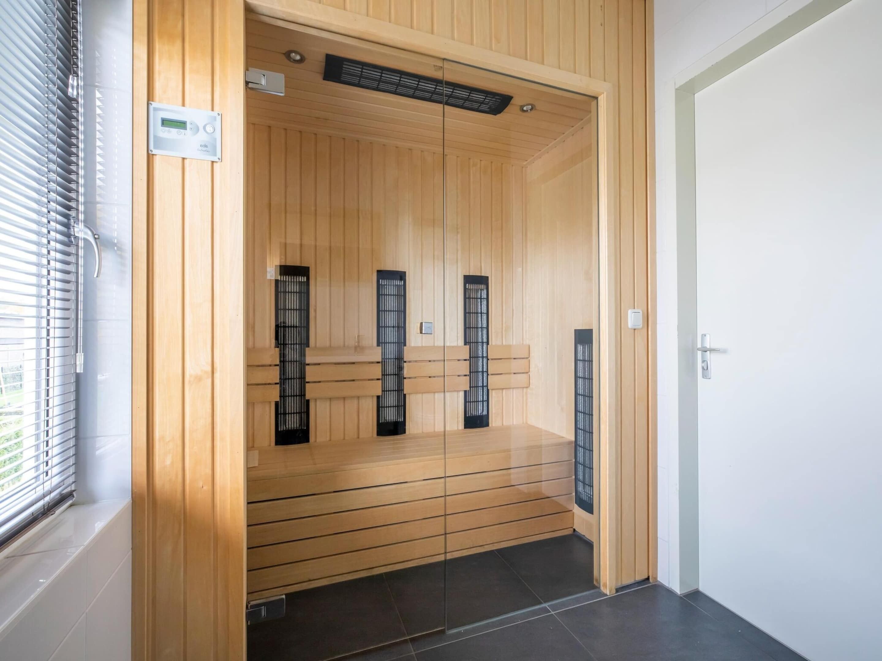 Una sauna con paredes de madera y panel de control digital.