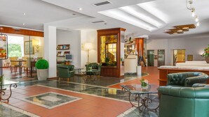 En rymlig entréhall med en stor sittgrupp, en receptionsdisk och utsikt över omgivningarna.