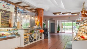 Ett bageri med ett skyltfönster av glas där bakverk visas, och en skylt med texten ”La Cantina di Angelo”.