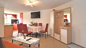 A compact living space with a dining area, a kitchen, and a seating area with a table and chairs. - Cozy Apartment in Lichtenhain Germany With Garden (Sebnitz)
