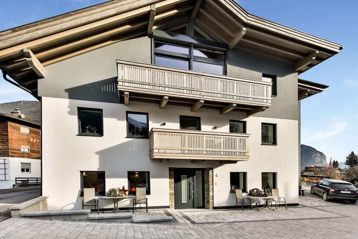 Un bâtiment moderne à deux étages, doté d’un balcon, d’une allée et offrant une vue sur les montagnes.