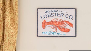 A wall-mounted sign for Nantucket Lobster Co. with a lobster illustration.