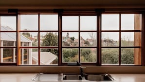 A kitchen with a large window and a sink. - Family Home in central Sandy Bay (Sandy Bay)