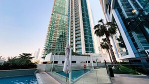 Un hôtel moderne doté d’une piscine et entouré de grands immeubles.