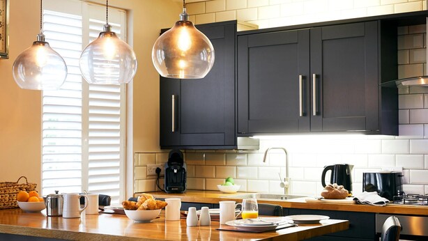 A modern kitchen with dark cabinets, a wooden countertop, and pendant lighting. - Luxury 2-bedroom apartment  in sleepy Filey on the North Yorkshire coast  (Filey)