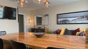 A modern dining area with a wooden table, black chairs, and pendant lighting. - Luxury 2-bedroom apartment  in sleepy Filey on the North Yorkshire coast  (Filey)