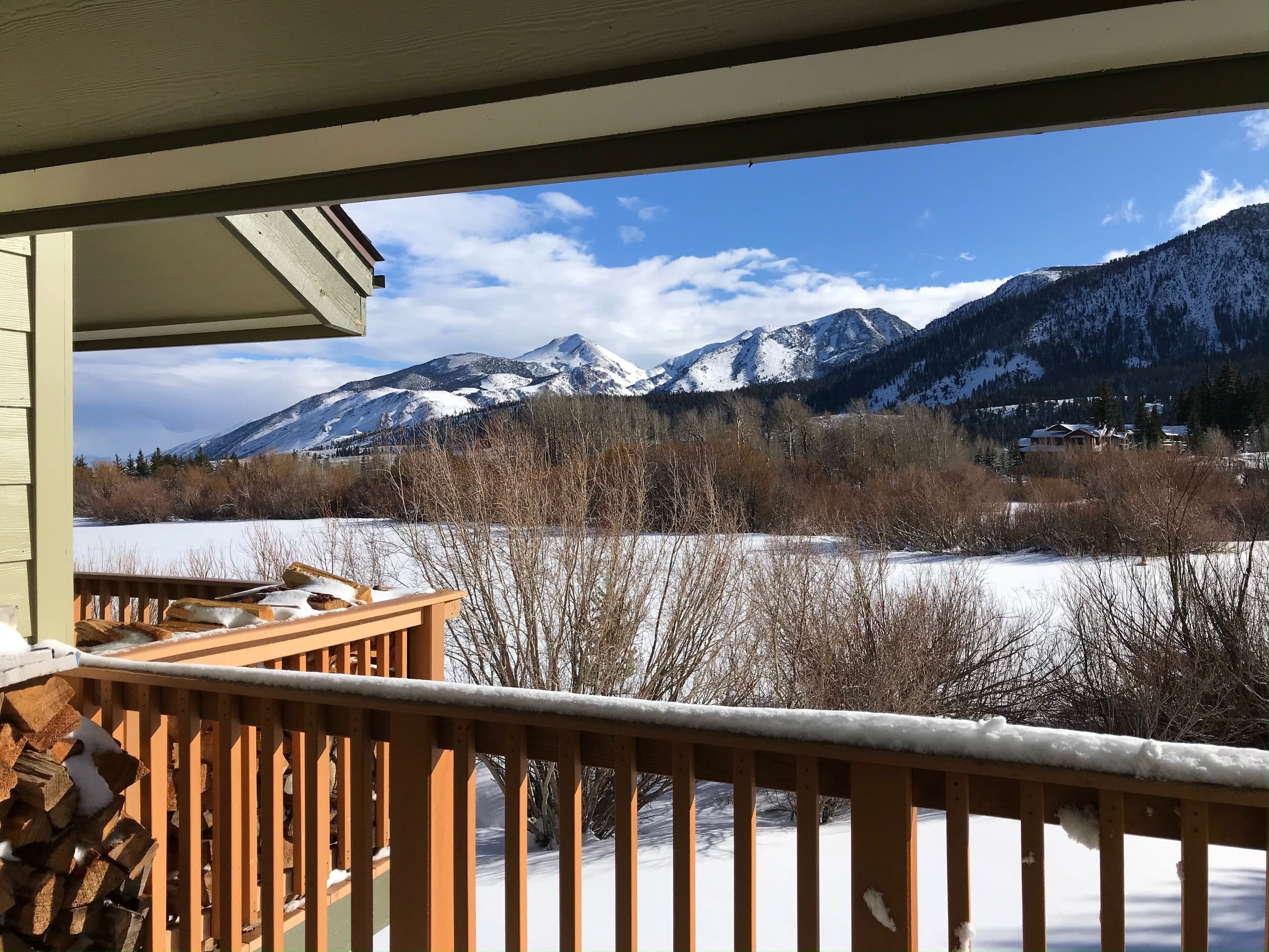 Ein Balkon mit Blick auf schneebedeckte Berge und einen Fluss.