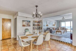 Un vaste espace de vie comprenant une table à manger, des chaises, une bibliothèque et un canapé.