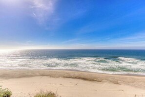 Une plage avec un ciel dégagé et des vagues sur l’océan.