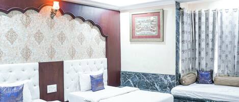 A hotel room with two beds, a marble accent wall, a framed picture, and a decorative wall sconce.