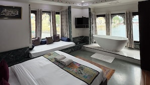 Une chambre d’hôtel avec deux lits, une baignoire et une grande fenêtre donnant sur un pont.