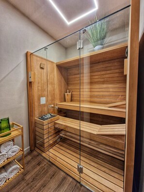 A modern sauna with wooden benches and a glass enclosure. - Relaxation and design in the center of Lucca (Lucca)