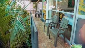 A covered outdoor seating area with chairs and tables, surrounded by greenery. - Amazonas Explorers Leticia (Leticia)