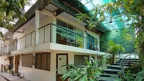 A two-story building with a balcony on the upper floor, surrounded by lush greenery and a staircase leading to the entrance. - Amazonas Explorers Leticia (Leticia)