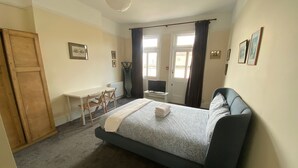 Un dormitorio con una cama, un escritorio y una silla.