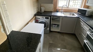 Una cocina compacta con lavadora, microondas y lavaplatos.