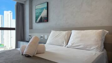 A hotel room with a bed, pillows, and towels.