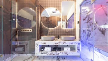 A modern bathroom with two sinks, a large mirror, and a glass shower enclosure.