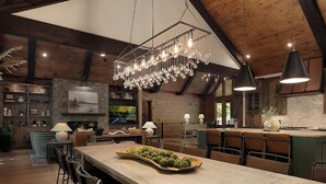 A spacious kitchen with a large island, wooden beams, and a hanging light fixture. - Iron Tree Lodge Blue Ridge GA (Blue Ridge)