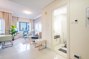 Relax in a stylish living area with a sofa, armchairs, and dining table, offering a city view.