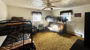 A room with bunk beds, a ceiling fan, a sofa, and a TV. - Charming retreat house (Spur)