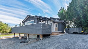 A modern two-story house with a grey exterior, a front porch, and a driveway.